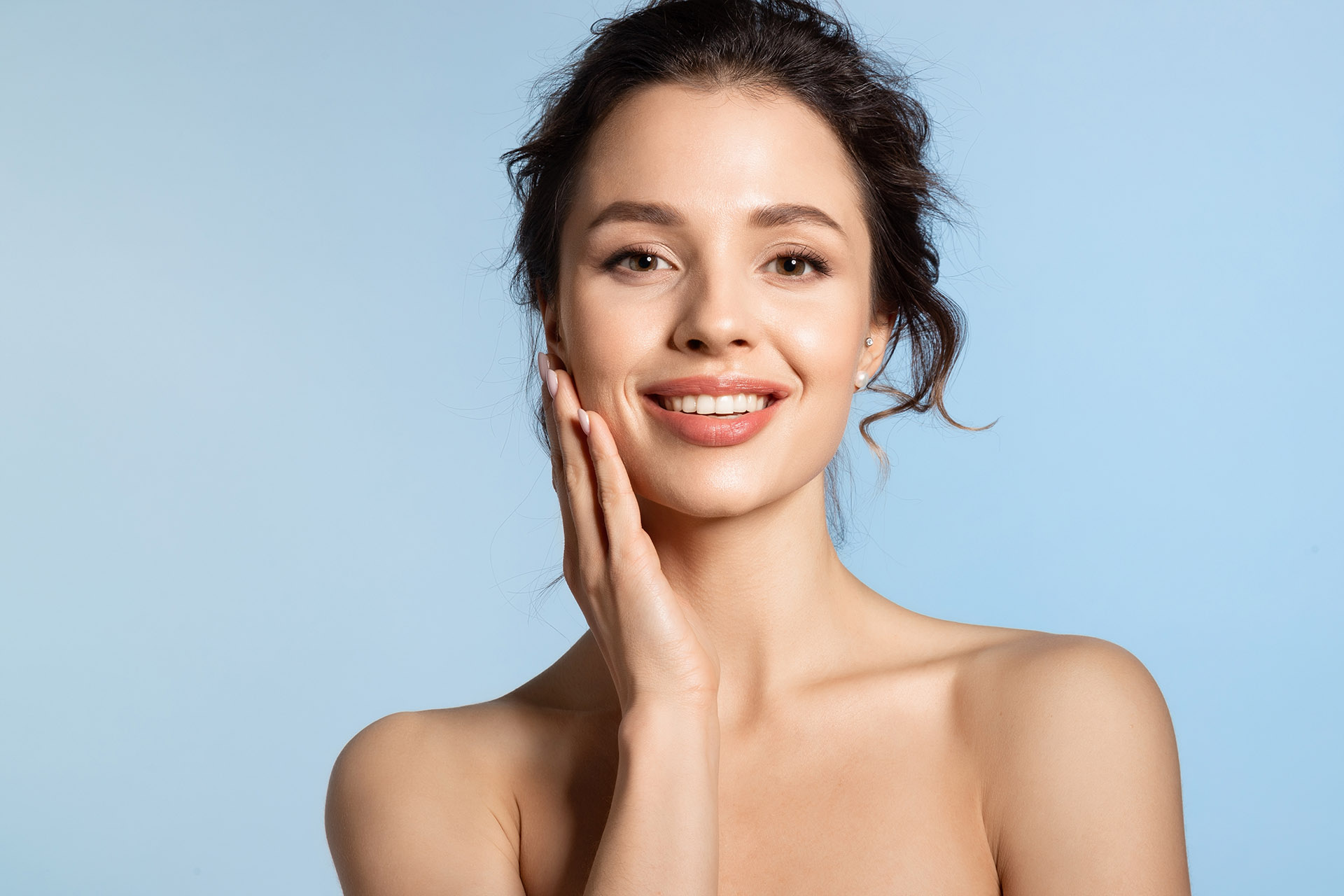 Young woman feeling smooth skin by touching cheek Young woman feeling smooth skin by touching cheek